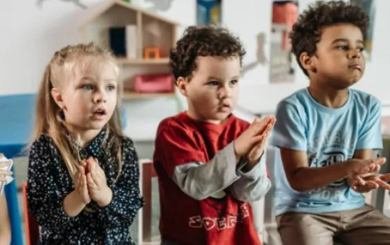 three elementary children clasping hands