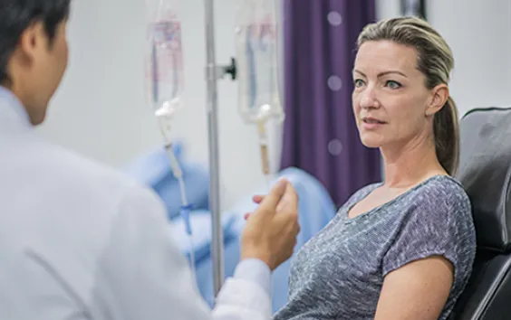 Woman with IV talking to patient