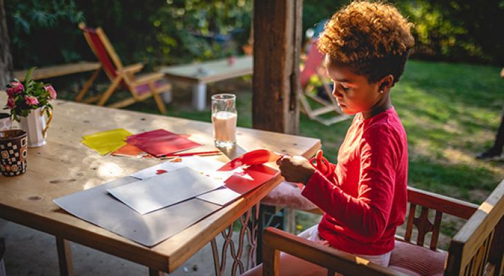 Image of elementary age child doing crafts outdoors
