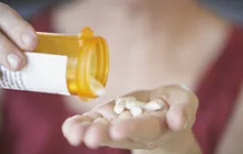 Image of hand with bottle of pills 