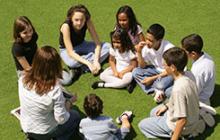 Image of kids in a circle with teacher outside after school