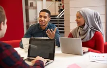 Image of two students working together at a table 