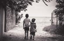 Image of two boys walking together, arm in arm