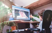 Image of child giving teacher on screen a thumbs up