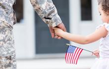 Image of girl with flag holding soldier's hand
