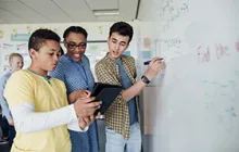 Image of students and teacher at whiteboard