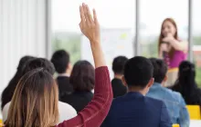 Woman raising her hand in a group