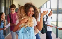 Girls hugging in school hallway