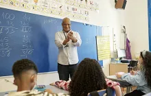 Smiling teacher at chalkboard