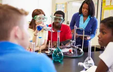 Teacher and high school students in chemistry lab