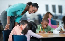 Teacher checking in on students writing