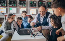 Teacher showing computer experiments to children 