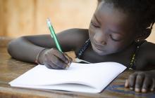 Young African girl writing in workbook