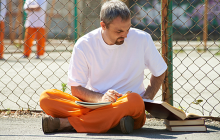 Man reading books at prison yard