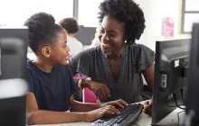 Teacher and student at desktop computer