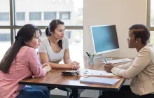 Loan officer talks with Hispanic mother and daughter
