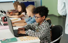 African American student working at a laptop at school
