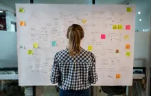 Young worker at strategy board with post-it notes