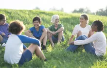 Middle school kids sitting in the grass