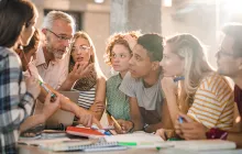 Mature teacher teaching group of college students at campus