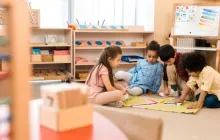Four children sitting on floor making a color pattern 