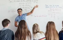 teacher pointing to a whiteboard