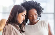 two women looking at a tablet together
