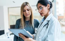 doctor talking while explaining medical treatment with digital tablet to patient in the consultatio