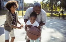 Older man playing basketball with grandchildren