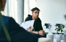 teen boy meeting with adult with clipboard