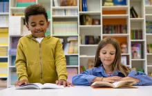 boy and girl elementary students reading together