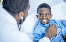 doctor using stethoscope on young patient