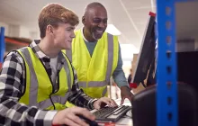 intern and supervisor working on computer in warehouse
