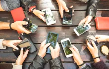 circle of hands holding cell phones
