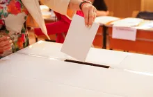 Woman putting ballot into box