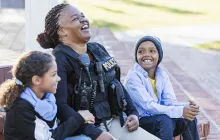 Policewoman laughing with kids outside