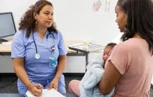 woman with newborn at doctor visit