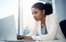 woman at work looking thoughtfully at computer