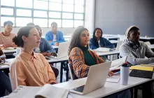 Adult students in classroom with laptops