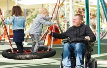 Man in wheelchair with children at the park