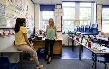 Teachers discussing lesson plans in a classroom