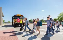 Students entering school with crossing guard