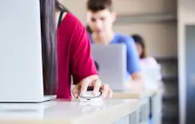 Female student clicking a mouse