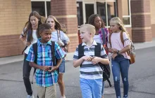Happy kids leaving school building