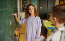Young student doing a math problem at chalkboard