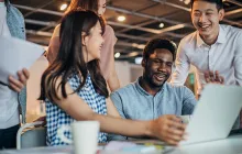 Diverse happy colleagues at a laptop