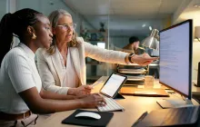 Older and younger colleagues working with data