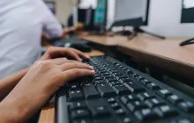 Hands at a computer keyboard