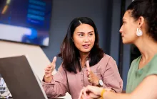 Two female colleagues discussing their work