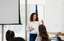 Teacher answering questions in front of a classroom